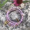 rosary bracelet with purple glass and goldtone beads on memory wire