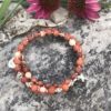 rosary bracelet with red onyx and silvertone beads on memory wire